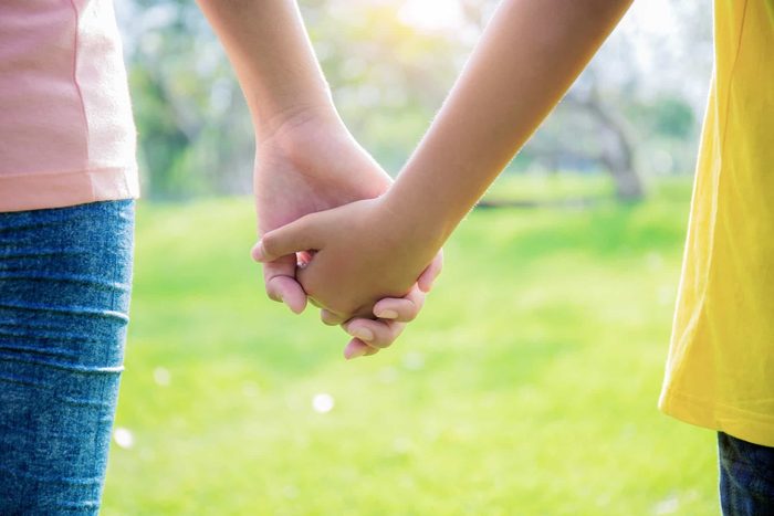 Two girls holding hands in a park